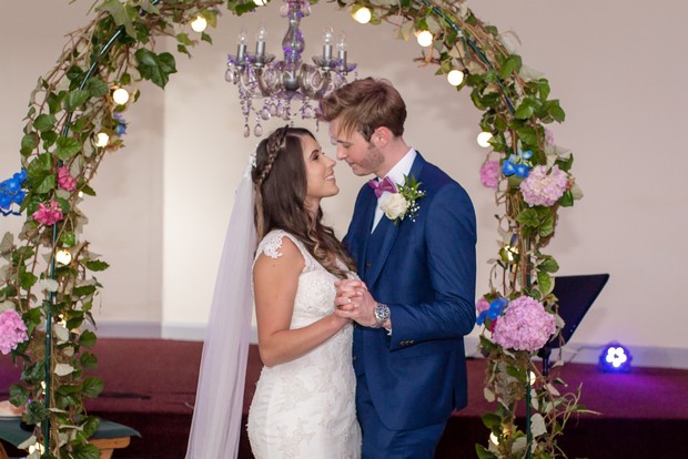 loughrea-hotel-real-wedding-paul-duane-ceremony-bride-and-groom-under-floral-arch