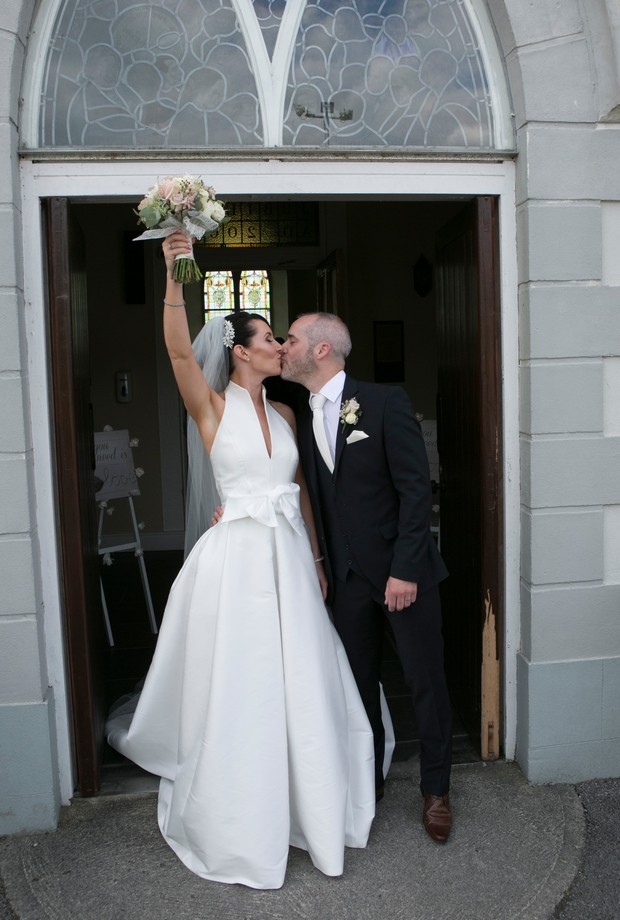 bride-and-groom-kissing-outside-church